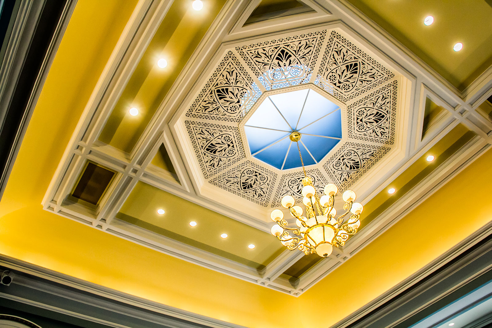 A golden ceiling with a beautiful chandelier